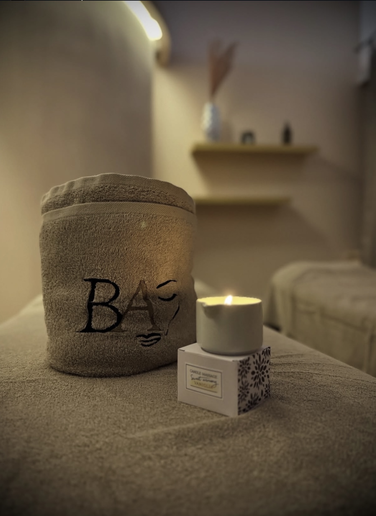 Atmosfera Beauty Art — telo con logo e candela accesa sul lettino